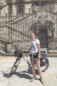 Anja Katharina Elmsheuser Mentoring Marburg Seelen-Alchemie: Ankunft mit dem Fahrrad vor der Kathedrale in Santiago de Compostela als Symbol für die geschaffte Heldenreise und das aufrechte Rückgrat mitten im Leben.